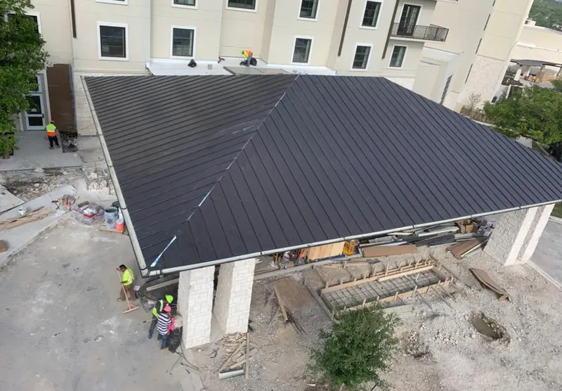 Metal roofing installation team working on a commercial building in Laurel